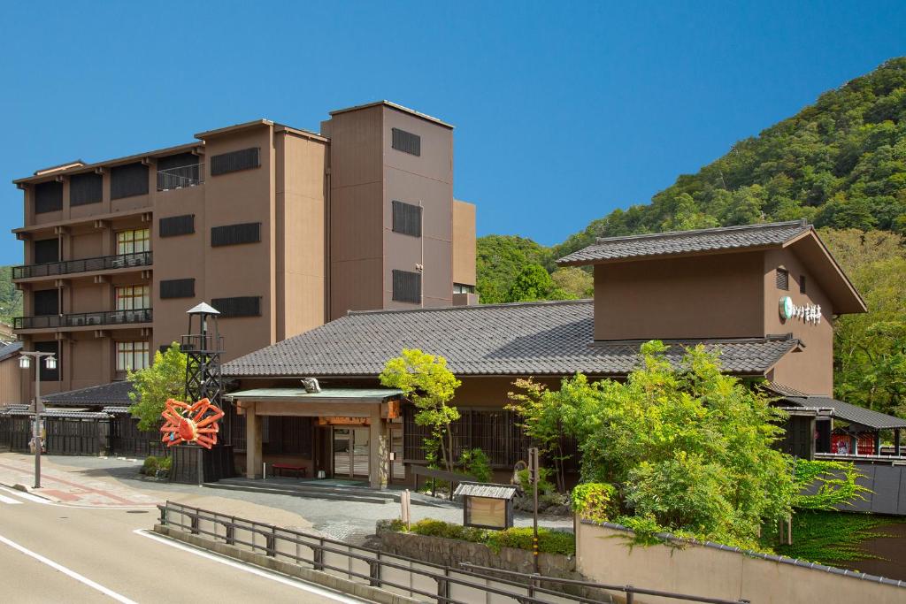 a building on the side of a street with a mountain at Yamanaka Onsen Kagari Kisshotei in Kaga