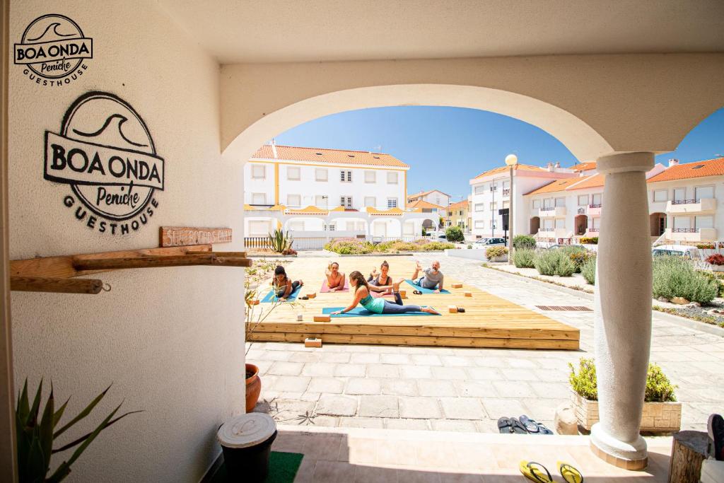 a group of people doing yoga in a courtyard at Boa Onda Guesthouse in Peniche