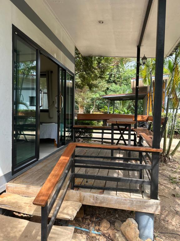 une terrasse couverte d'une maison avec un banc en bois dans l'établissement Fine Times Resort, à Ko Chang