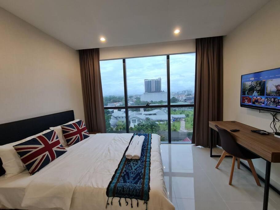 a bedroom with a bed with a desk and a large window at Lovely Kozi Square Studio Bedroom with Pool LV5C in Kuching