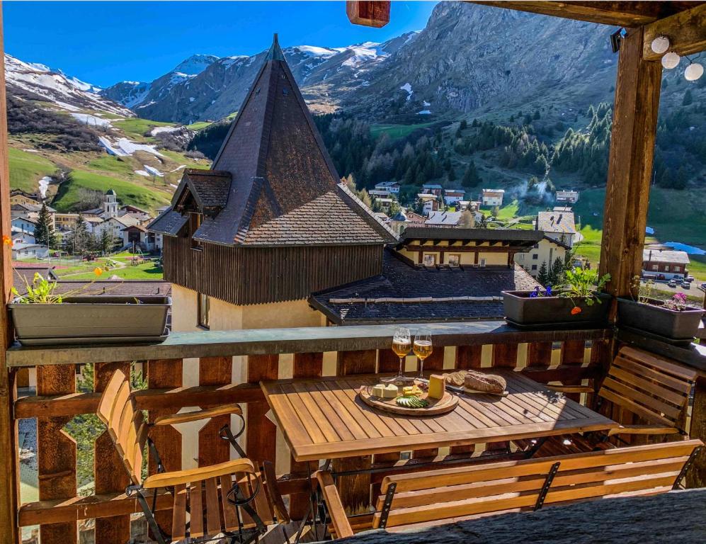 a table on a balcony with a view of a mountain at Heimelige Ferienwohnung mit Sicht in die Bergwelt in Bivio