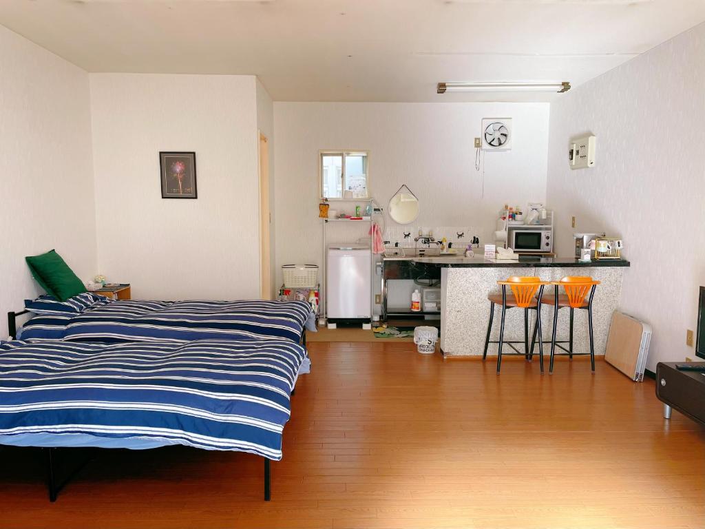 甲府市にある富竹民泊のリビングルーム(ベッド2台付)、キッチンが備わります。