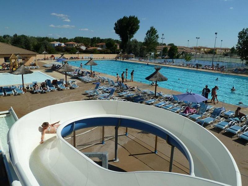 Una gran piscina con mucha gente. en Mobil home 6 ou 8 pers Au camping Le Grau-du-Roi Domaine l'Elysée, en Le Grau-du-Roi