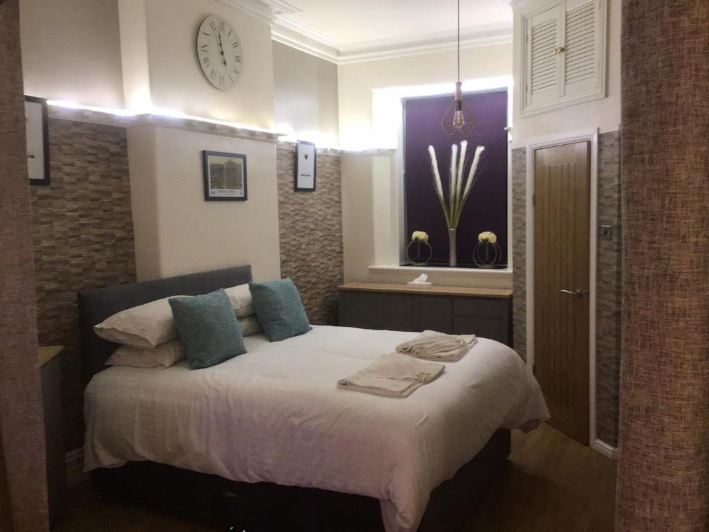 a bedroom with a bed and a clock on the wall at Ravensworth House in Keswick