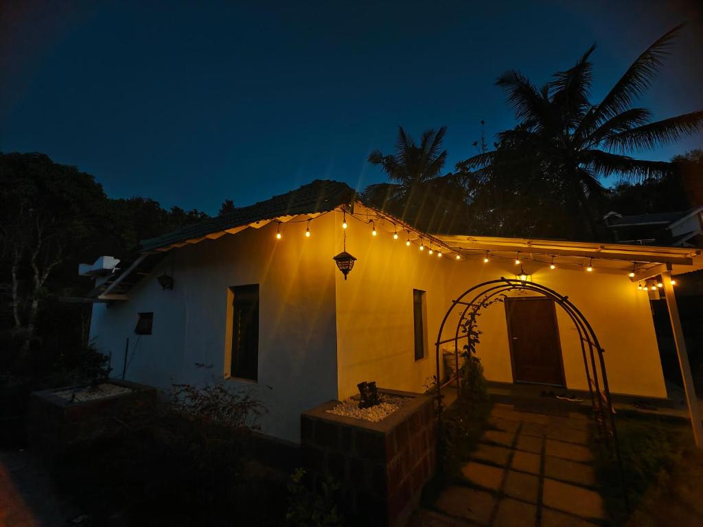 ein weißes Haus mit Lichtern in der Nacht in der Unterkunft Multiple Stories, Wayanad in Wayanad