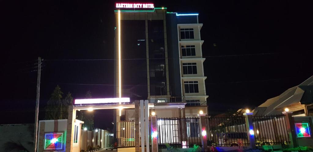 un edificio blanco alto con un cartel en él por la noche en Eastern City Hotel, en Dodoma