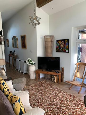 a living room with a couch and a tv at The Gallery, Warwick in Warwick