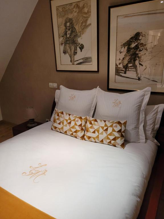 a bed with white sheets and pillows in a bedroom at La Merlette89 in Lailly