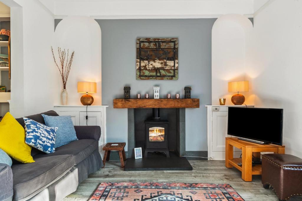 a living room with a couch and a fireplace at Sunbury Villa - Close to Town and Beaches in Tenby