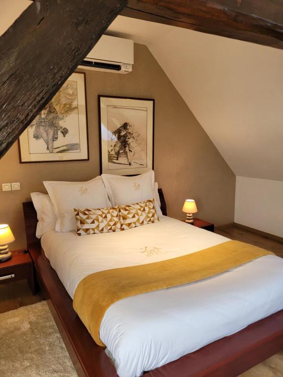 a bedroom with a large bed in a attic at La Merlette89 in Lailly