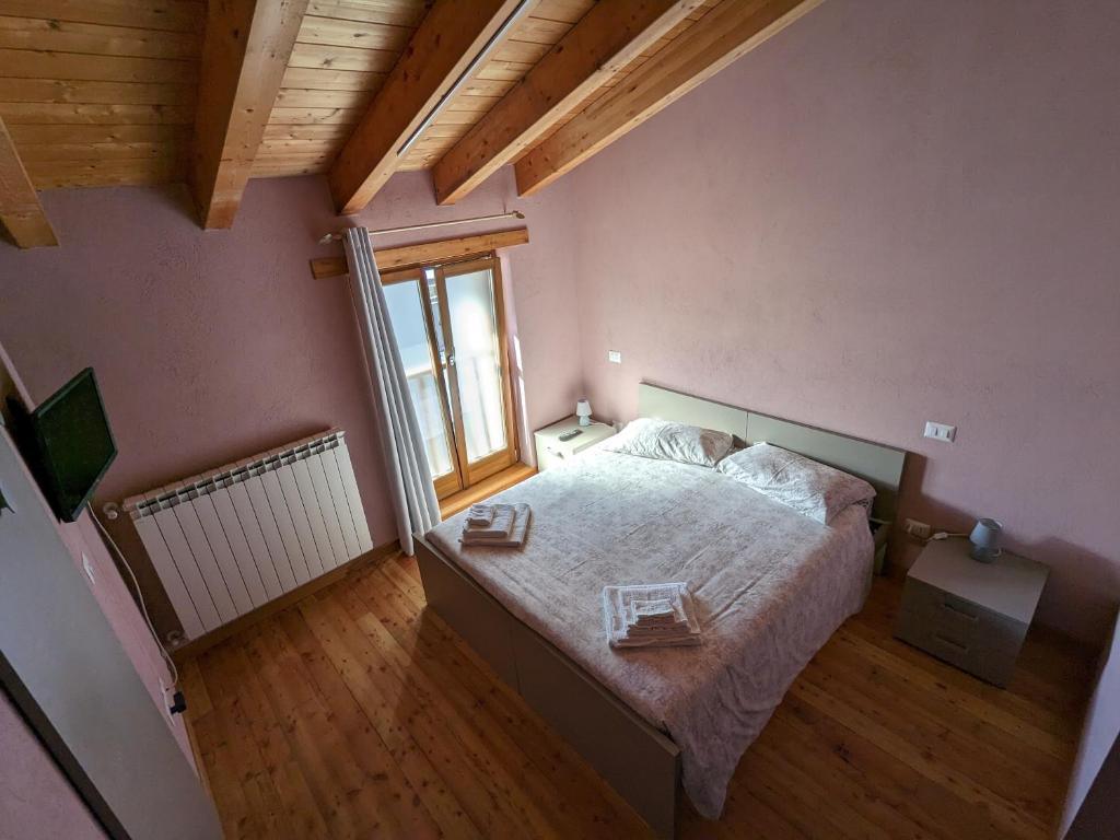 a bedroom with a bed and a large window at CONSTANCIA TRATTORIA in Valdieri