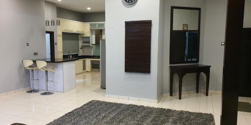 una cucina con bancone, tavolo e sedie di Luxury & Complete 3 Bedroom Penthouse a Shah Alam