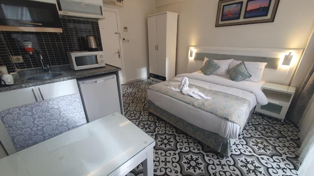 a small hotel room with a bed and a kitchen at Lemon Residence in Istanbul