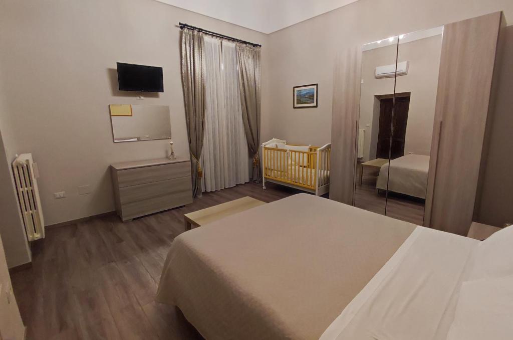 - une chambre avec un lit, un lit bébé et un miroir dans l'établissement Lo Stemma B&B Guest House, à Melfi