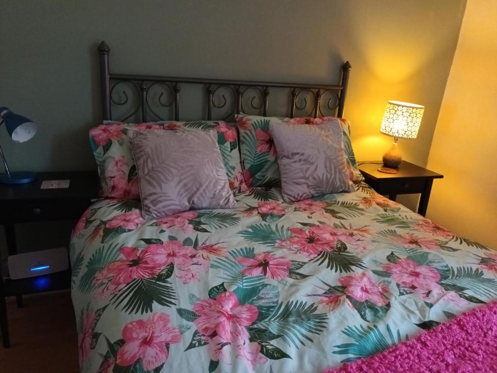 a bedroom with a bed with pink and green flowers at Dales View House in Barnoldswick