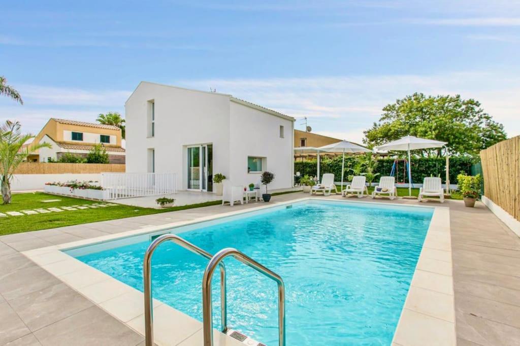 a swimming pool in the backyard of a house at Domus Maulli - Villa sul mare in Marina di Ragusa