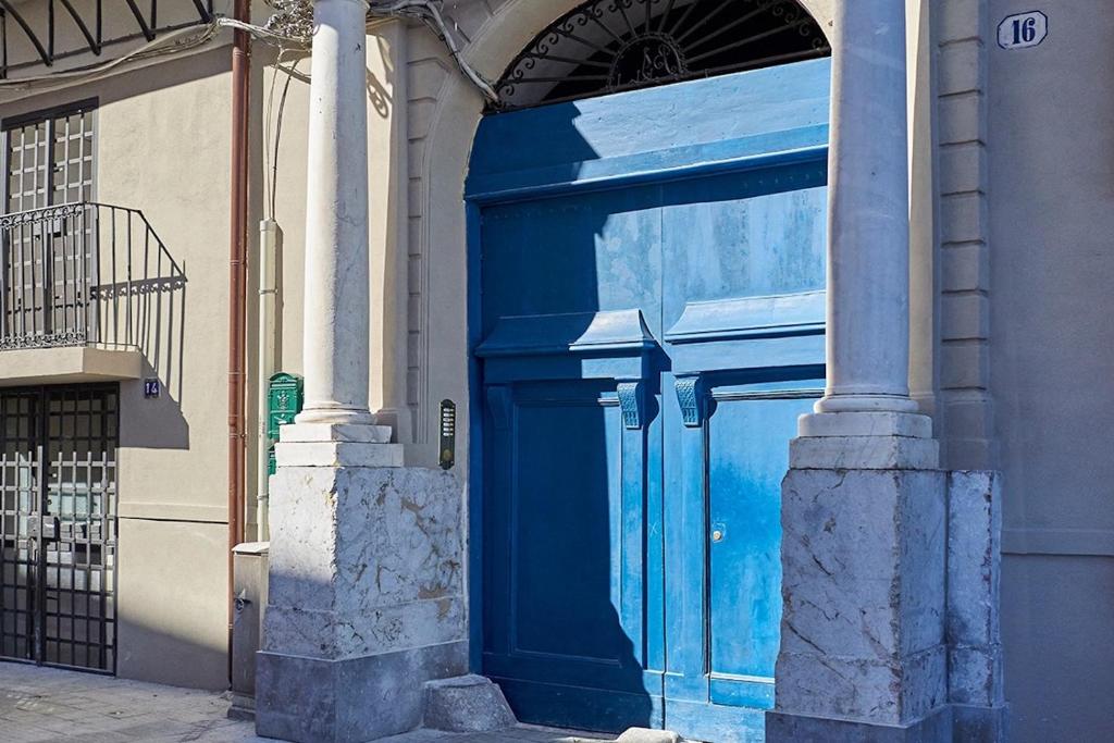 una puerta azul en el lateral de un edificio en La casa di Chele, en Palermo