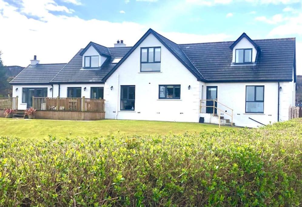 una casa bianca con tetto nero e cortile di Wild Atlantic Lodge a Dunfanaghy