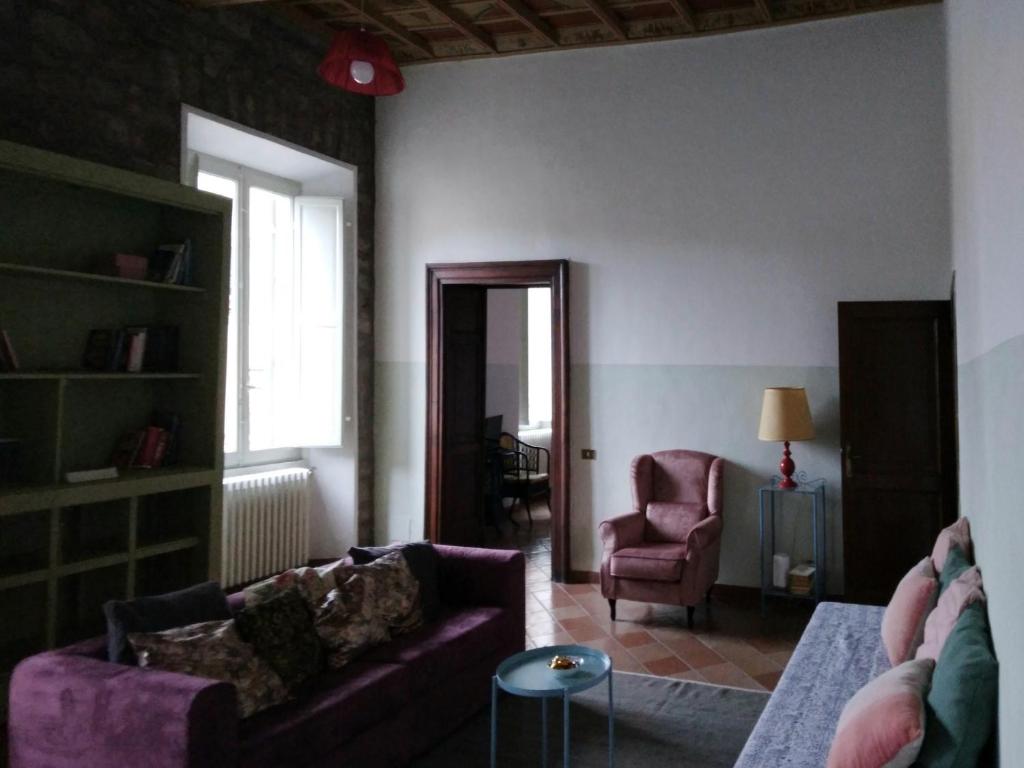 ein Wohnzimmer mit einem lila Sofa und einem Stuhl in der Unterkunft pietrolafontaine19 in Viterbo