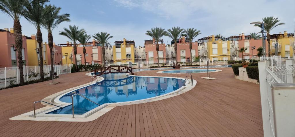 uma grande piscina com palmeiras e edifícios em Vera playa laguna beach em Vera