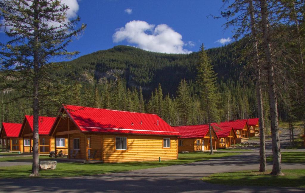 
a red brick building with a red roof and trees at Jasper East Cabins in Jasper
