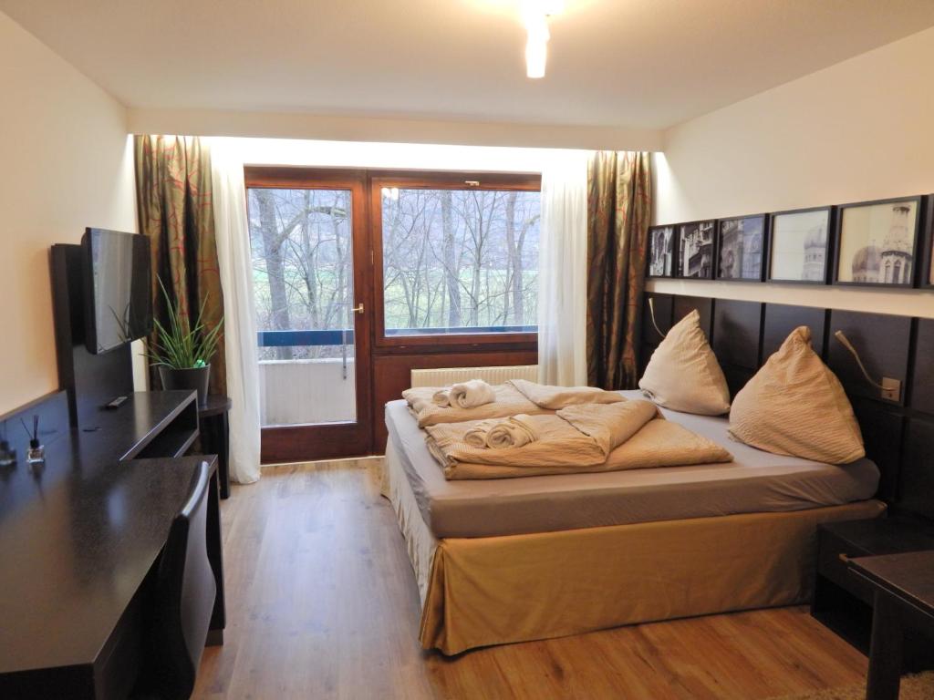 a bedroom with a bed and a desk and a television at FREE Apartment - Am Brühlbach in Bad Urach