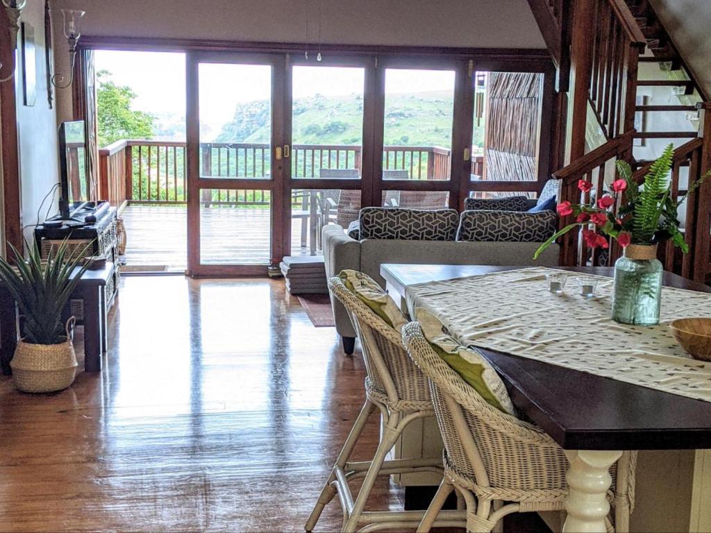 a living room with a table and chairs and a porch at Eagles Call in Port Edward