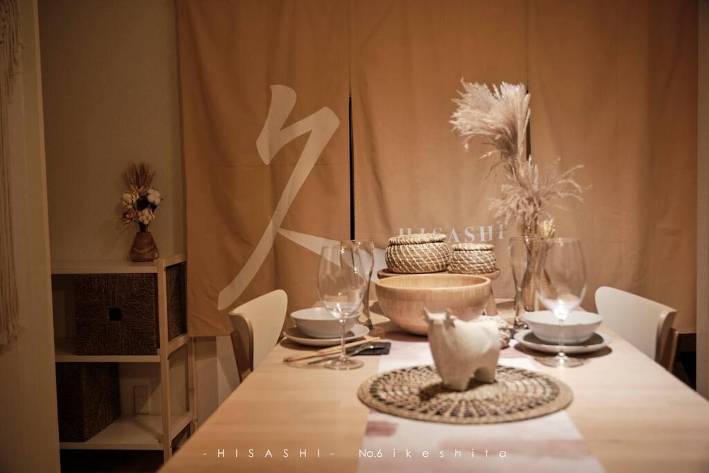 mesa de comedor con mantel blanco y mesa en 久Hisashi池下店民泊 en Chikusachō