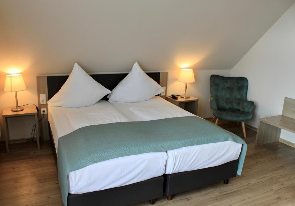 メーデバッハにあるTroll's Brauhaushotelのベッドルーム1室(ベッド1台、緑の椅子付)