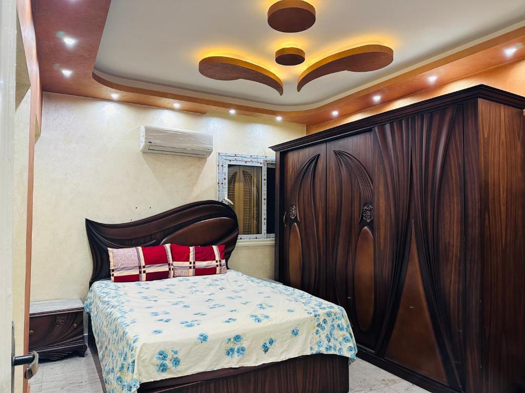 sypialnia z łóżkiem i drewnianą szafką w obiekcie 91 الميرلاند الدور 7 w Kairze