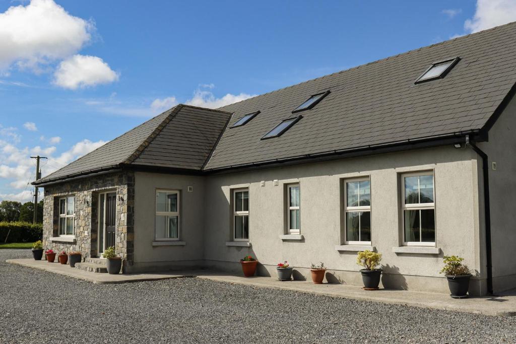 a house with potted plants in front of it at Woodview Lodge in Trim