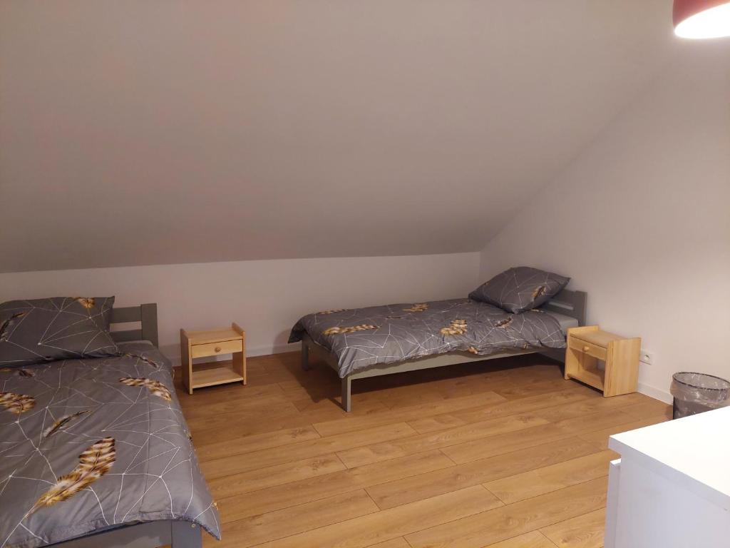 1 Schlafzimmer mit 2 Betten und Holzboden in der Unterkunft Pokoje Kraków Tyniec in Krakau