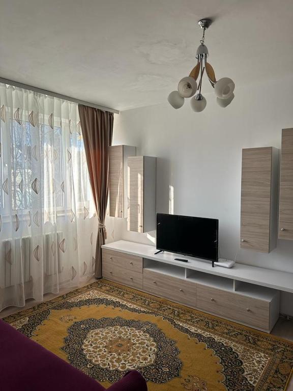 a living room with a flat screen tv on a dresser at Velovan Apartment in Craiova