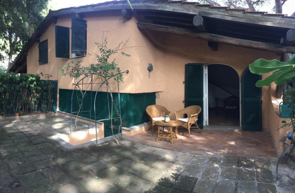 a house with a table and chairs in front of it at VILLETTA CON SPIAGGIA PRIVATA ALLE DUNE in Castiglione della Pescaia