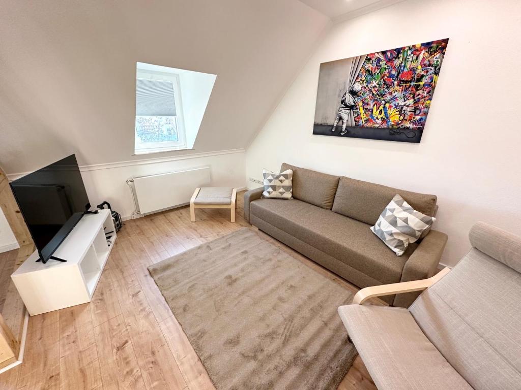 sala de estar con sofá y TV en Stadthaus Apartment Bachperle, en Mayen