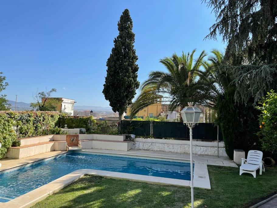 a swimming pool in the yard of a house at Villa a los pies de la Alhambra in Granada