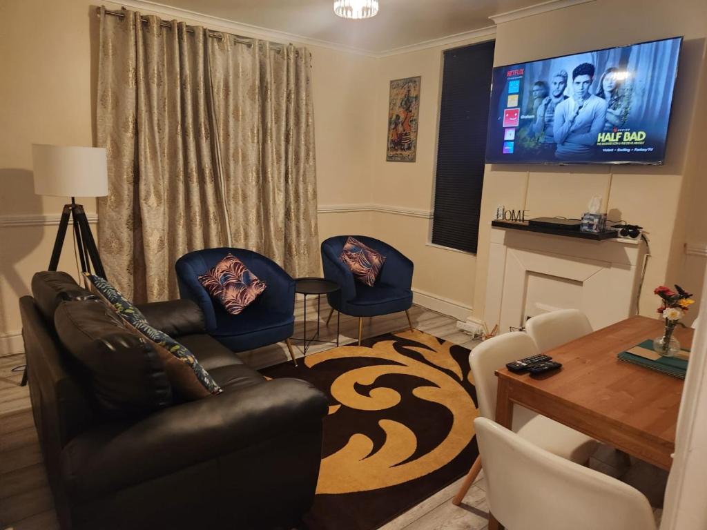 2-bedroom flat in Cutty-Sark, Greenwich ! في لندن: غرفة معيشة بها أريكة وكراسي وتلفزيون