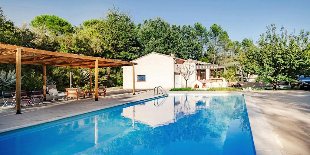 une piscine devant une maison dans l'établissement Villa climatisée avec piscine, à Bagnols-en-Forêt