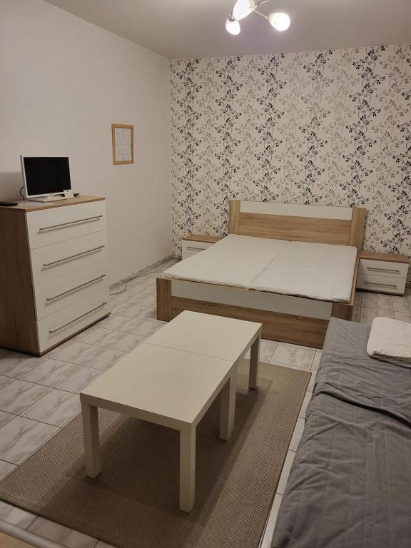 a bedroom with two beds and a dresser in it at Zwaan Apartmány in Dunajská Streda