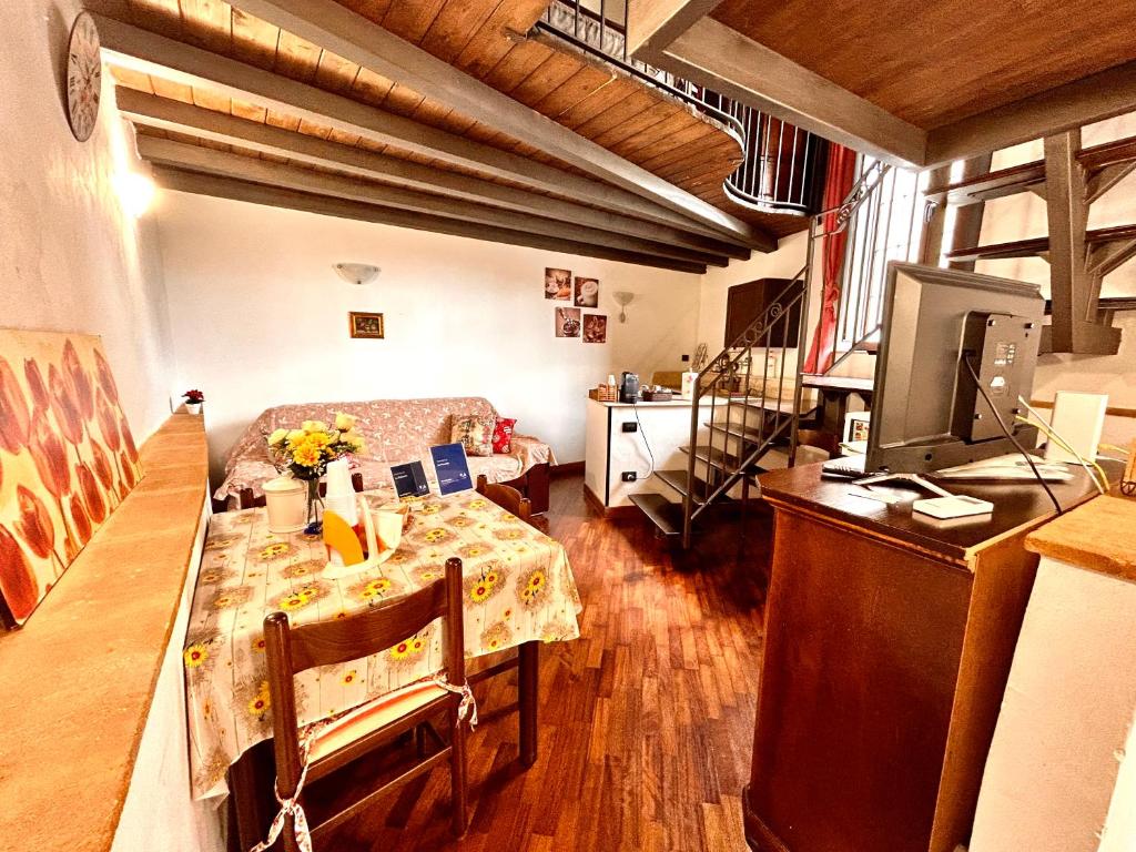 una pequeña sala de estar con mesa y TV en La Trinacria en Agrigento