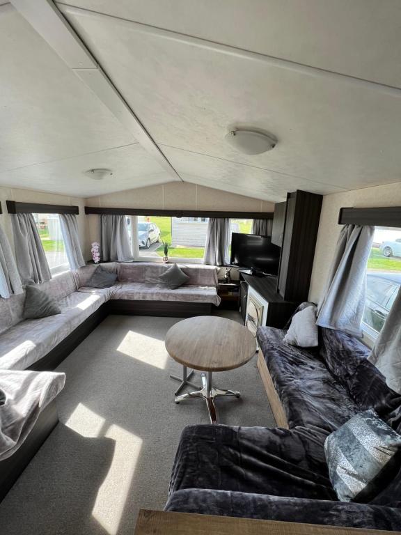 a living room with a couch and a table at Fieldview 43 in Leysdown-on-Sea