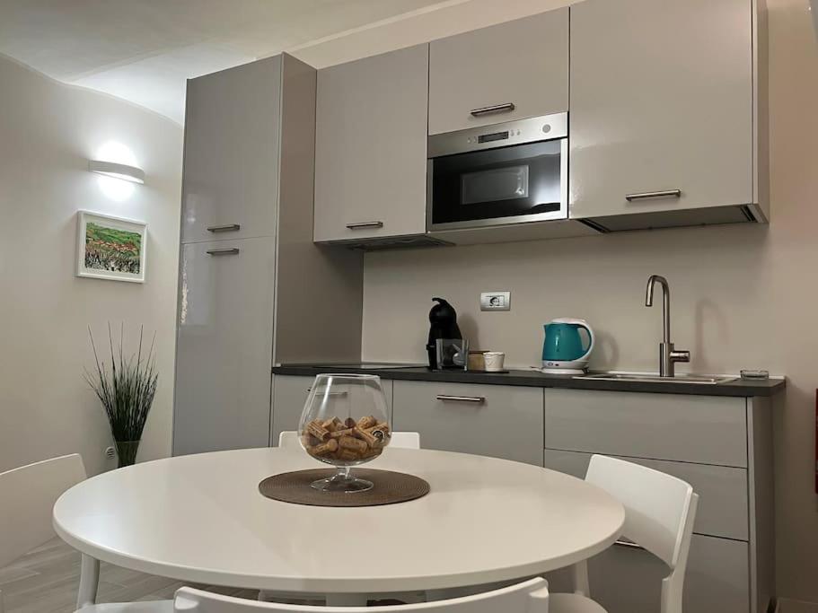 a kitchen with a white table with a wine glass on it at Casa Patrito - appartamento Barbera in Barolo