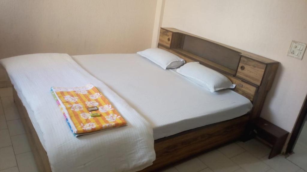 a bed with a wooden headboard and a blanket on it at Mufis Homestay, Emerald Compound, New Palam Vihar-2 in Gurgaon