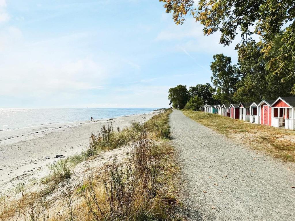 a row of beach huts on a sandy beach at Holiday home Löderup V in Löderup