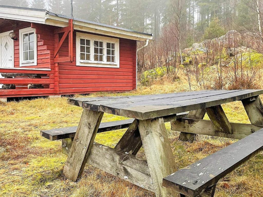 a wooden picnic table in front of a cabin at Holiday home SEXDREGA in Sexdrega