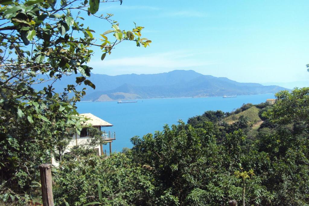 uma vista para o oceano a partir de uma colina com uma casa em Le Refuge Suites em Ilhabela