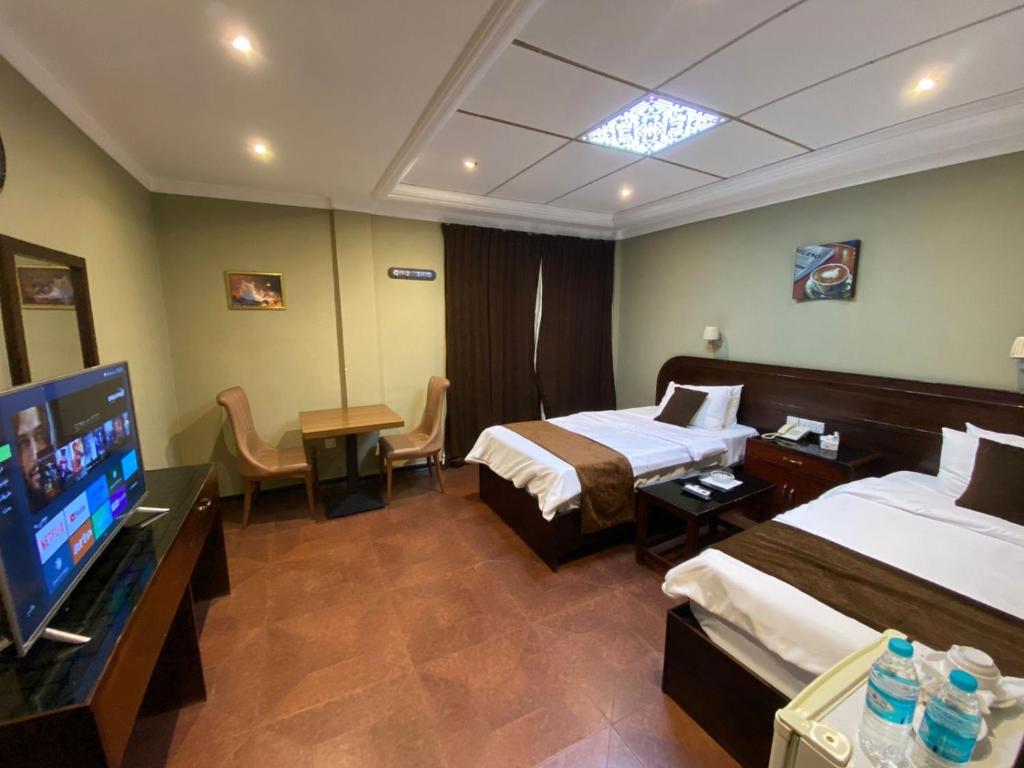 Cette chambre comprend 2 lits et une télévision à écran plat. dans l'établissement Castle Hotel, à Bassorah