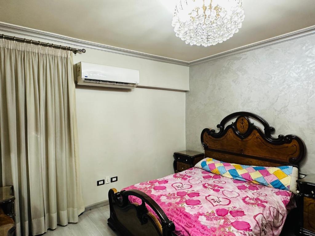 a bedroom with a bed and a chandelier at 100برج الثورة الدور 2 in Cairo