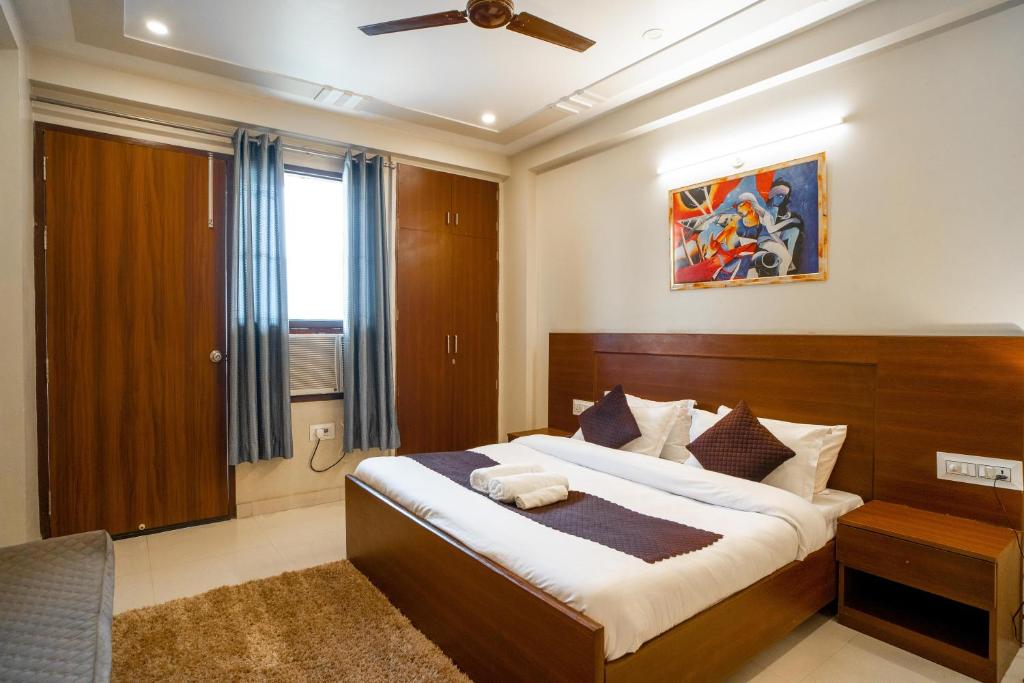 The Lodgers 2 BHK Serviced Apartment infront of Artemis Hospital Gurgaon في جورجاون: غرفة نوم بسرير كبير ونافذة