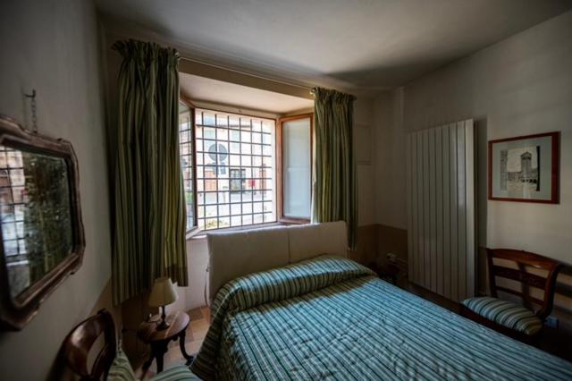1 dormitorio con cama y ventana en Palazzo Santinelli, en SantʼAngelo in Vado